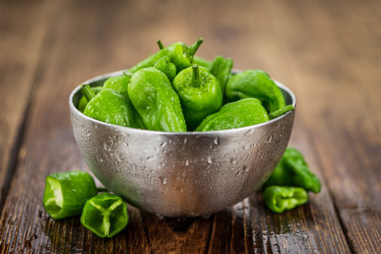 Portion of Raw Pimientos on wooden background, selective focus