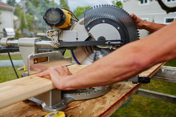 Man using saw to cut wood
