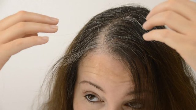 Young woman shows her gray hair
