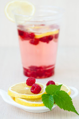 Lemon slices, drink, berries and raspberry leaves