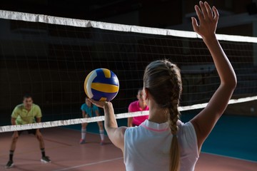 Rear view of volleyball player playing with teammates