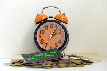Alarm clock, coin and car key with word "INSURANCE PROTECTION" - loan concept.