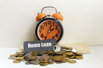 Alarm clock, coin and car key with word "HOME LOAN" - loan concept.