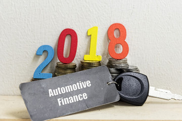 coin, car key and number 2018 -  concept image of automotive finance