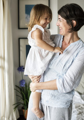 Naklejka premium Mother carrying daughter with smiling