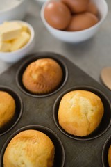 High angle view of muffins in tin by ingredients