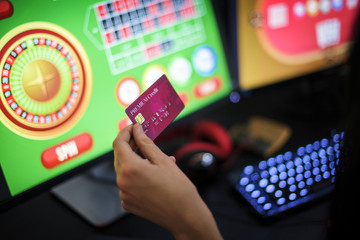 Hand holding credit card playing online gambling