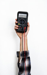 Hand holding electrics measure multimeter isolated on white