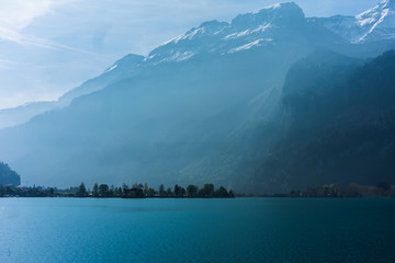 Beautiful scenery of crystal clear water in lake Brienz with background of snow covered alps mountain in Switzerland