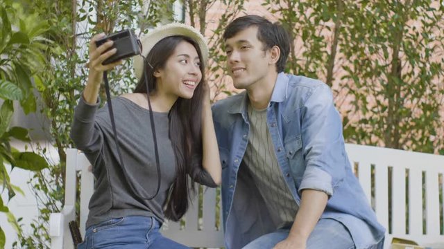 Happy young couple holding smartphone taking selfie and enjoying sunny day outside