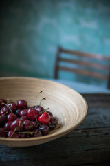 Cherry in a wooden plate in rustic style