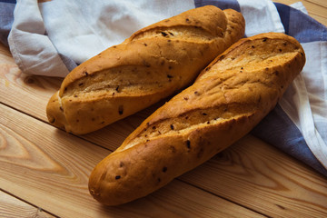 Two baguettes on a wooden background. Loafs on the table