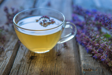 Green tea with herbals. Tea with oregano on the wooden background