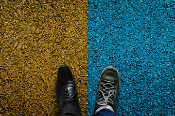 Life Balance Concept for Work and Travel present in top view position by half of Business Oxford and Adventure shoes, Cement Floor as background