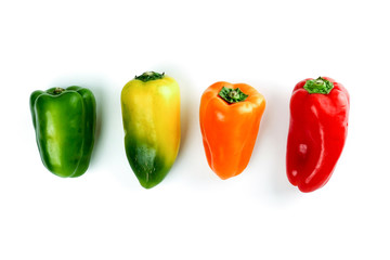 Green, red, yellow, orange bell peppers over white