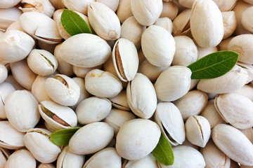 Pistachios background with green leaf