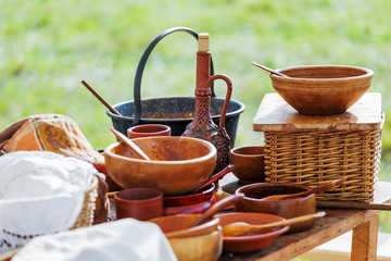 Wooden table with old fashioned wooden and earthenware crockery. Historical reconstruction of 19...