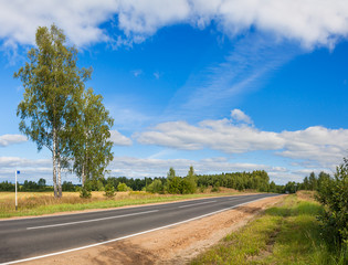 summer rural landscape panorama with road,forest,field and blue sky with white clouds