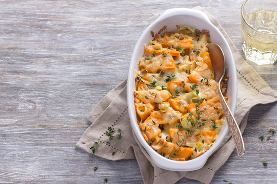 Pumpkin Gratin with leek, thyme and cheese on a gray background, selective focus