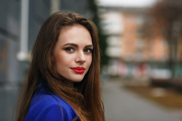Portrait of a young beautiful girl posing on a city street