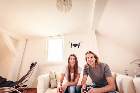 Young Couple Playing With A Small Quadrocopter Drone
