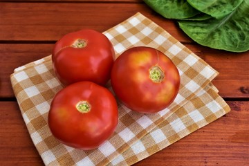 Whole tomatoes on a kitchen napkin.
