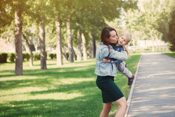 Young mother with little son having fun playing in the Park