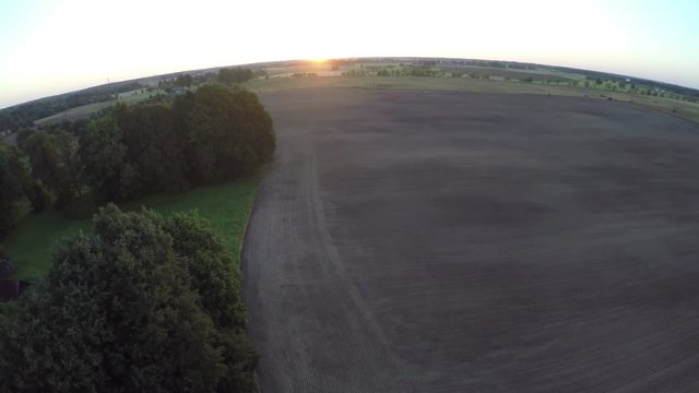 Summer edn sunrise over farmland with sowed cultivated fields, aerial view

