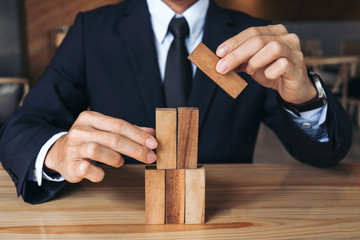 Businessman hand arranging stacking wooden blocks development as step stair, Business growth...
