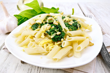 Pasta penne with spinach and nuts on light board