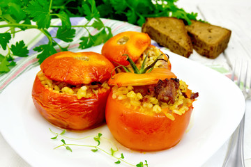 Tomatoes stuffed with bulgur and meat in plate on table