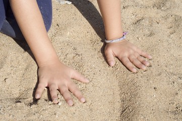 Fototapeta na wymiar hands in the sand