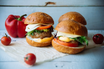 The traditional hamburger Patty, cheese, tomato, lettuce, beef Burger, takeaway. Dark wooden background, horizontal shot.