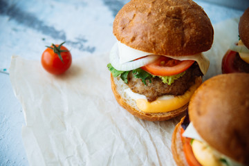 The traditional hamburger Patty, cheese, tomato, lettuce, beef Burger, takeaway. Dark wooden background, horizontal shot.
