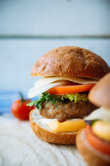 Tasty turkey burgers with corn salad and carrot,mixed seeds served on old board on a rustic wooden table with copyspace.