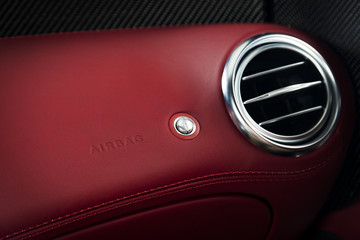 Ventilation deck in a luxury sports car with a red leather interior