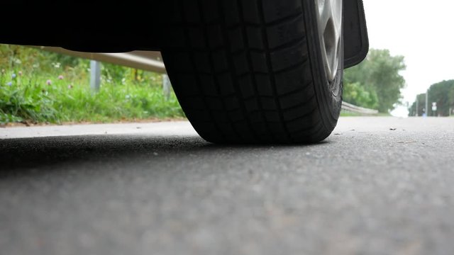 the wheel of a car is rolling down the road