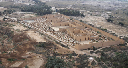 Restored ruins of the South palace of Nebuchadnezzar in ancient Babylon, Iraq on the right. Ruins of the North palace damaged by US occupation on the left. Beyond Processional Street is Ninmah temple.