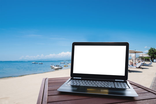 Laptop computer on wood table at the beach in summer © SasinParaksa