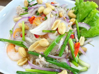Spicy vermicelli or glass noodle salad with mince pork, shrimp topping with peanut in Thai style