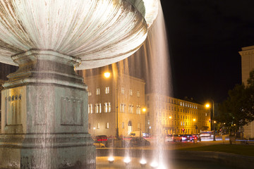 Beleuchteter Brunnen am Geschwister-Scholl-Platz in München