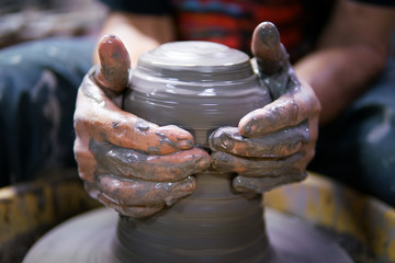 Man potter making ceramic pot on the pottery wheel