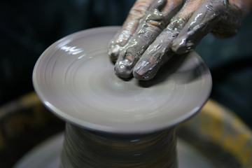 Man potter making ceramic pot on the pottery wheel