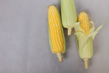 Fresh corn on cobs on texture background, closeup, top view