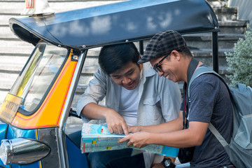 Asian travel photographer negotiates price with tuk tuk driver before traveling around Bangkok Landmark Thailand