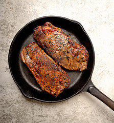 Fototapeta premium grilled steak and basil on a frying pan