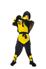 The seven-years old boy in black and yellow ninja suit with a hood and mask on his face bowed his head. With a knife in hand. Portrait in full growth