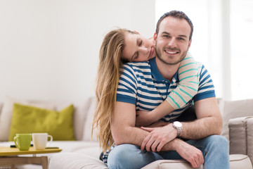 young handsome couple hugging on the sofa