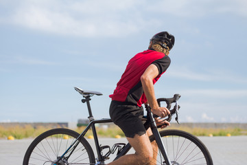 Obraz premium Professional bicycle rider in helmet and sportswear training on empty road 