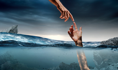 Hand of person drowning in water